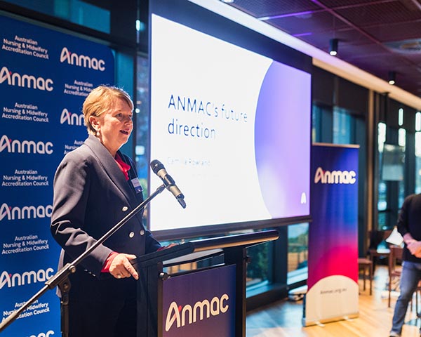 Anmac CEO speaks at a podium with "ANMAC's future direction" on a screen. Logos on banners suggest a formal conference setting.