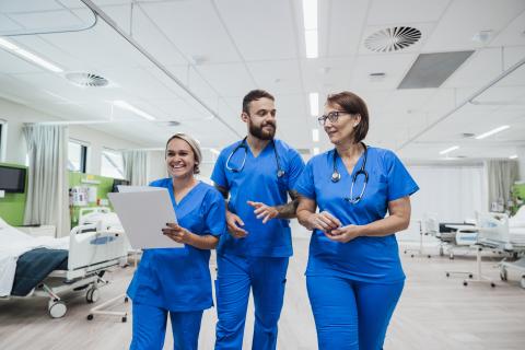 3 nurses talking in a hospital ward