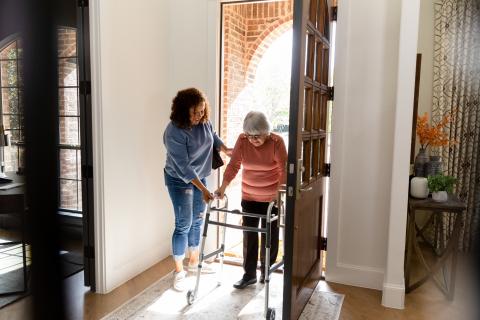 aged care worker helping older woman